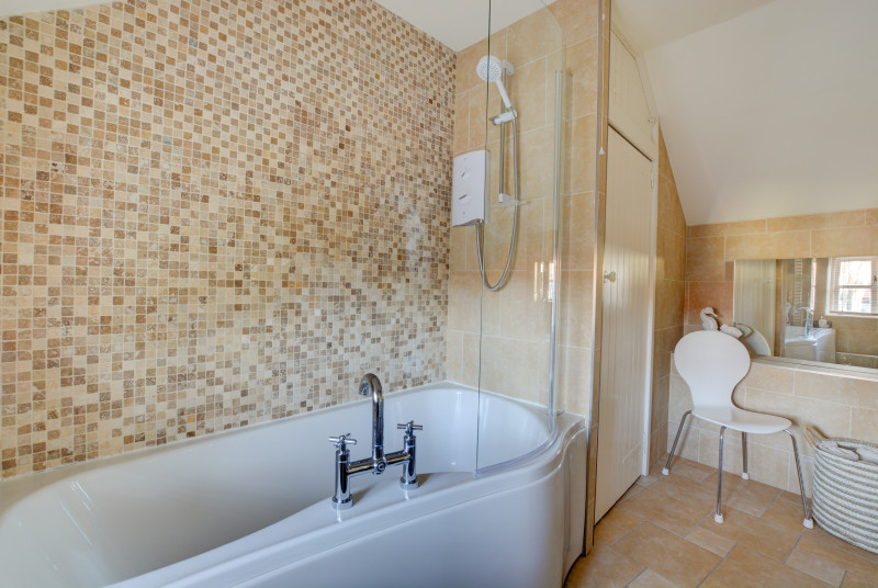 Modern tiled bathroom with bath and overbath shower