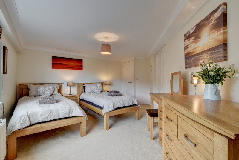 The twin bedroom is spacious and has comfortable wooden beds and a TV