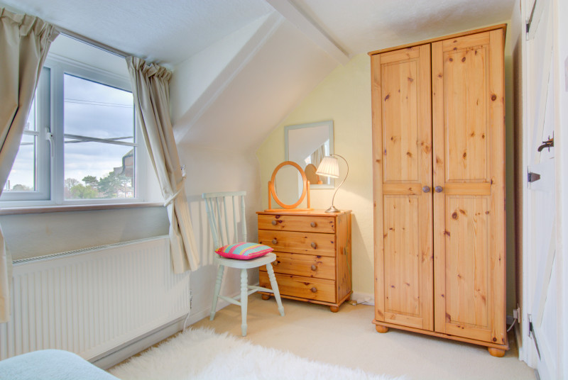 Plenty of storage with a wardrobe, chest of drawers, mirror and stool