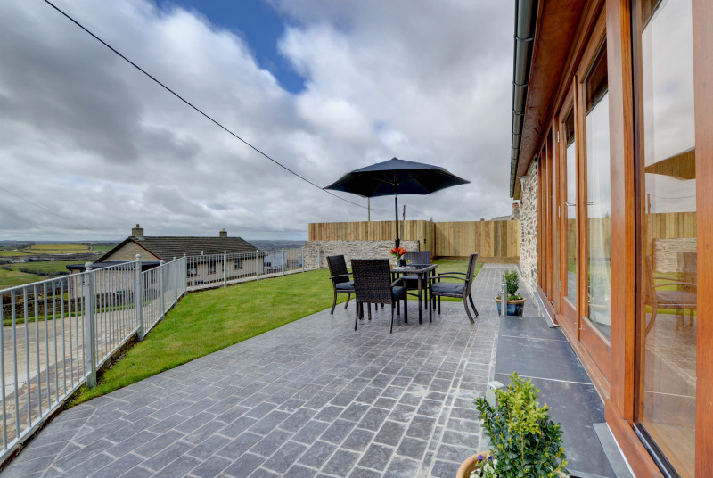 The property benefits from a large patio and grass area, perfect for taking in the views