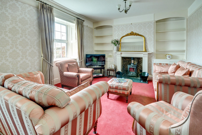 The cosy living room with woodburner in feature fireplace