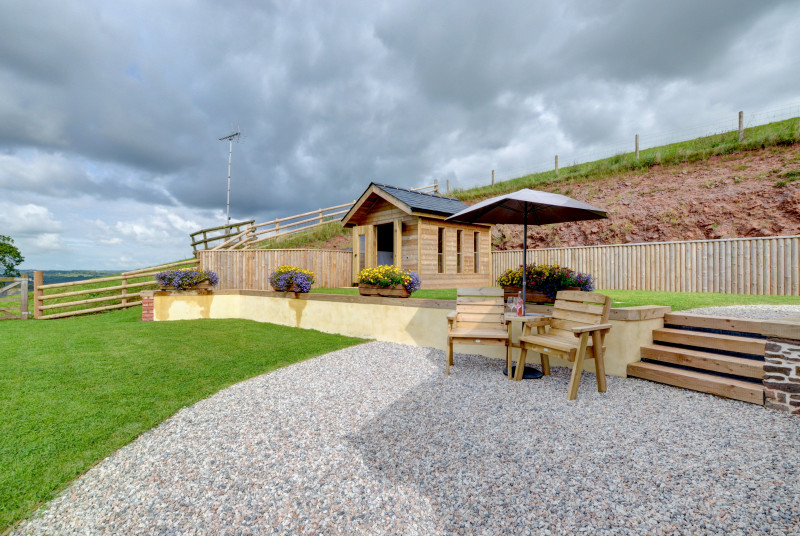 A external view of the patio and summerhouse with hot tub