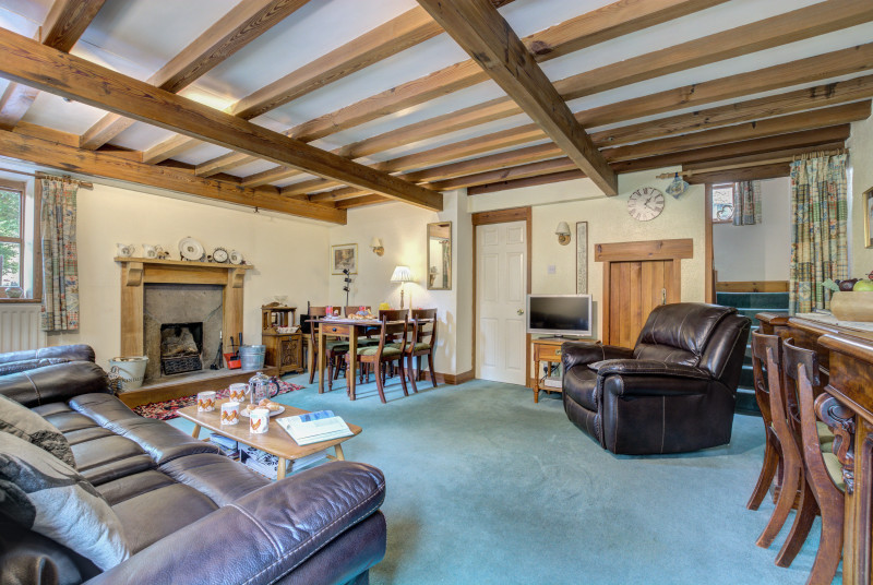 Spacious lounge and dining area with open fire and beamed ceiling