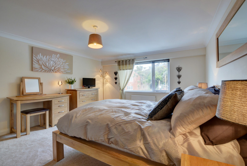 The stylish master bedroom with double bed and TV