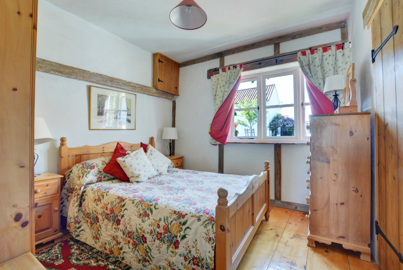Lovely cottage style double bedroom with a double bed and pine furniture