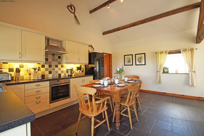 A spacious, cream 'shaker' style kitchen with a farmhouse pine table.