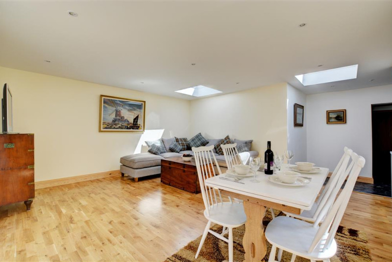 Open plan room with cosy corner sofa, dining table and chairs