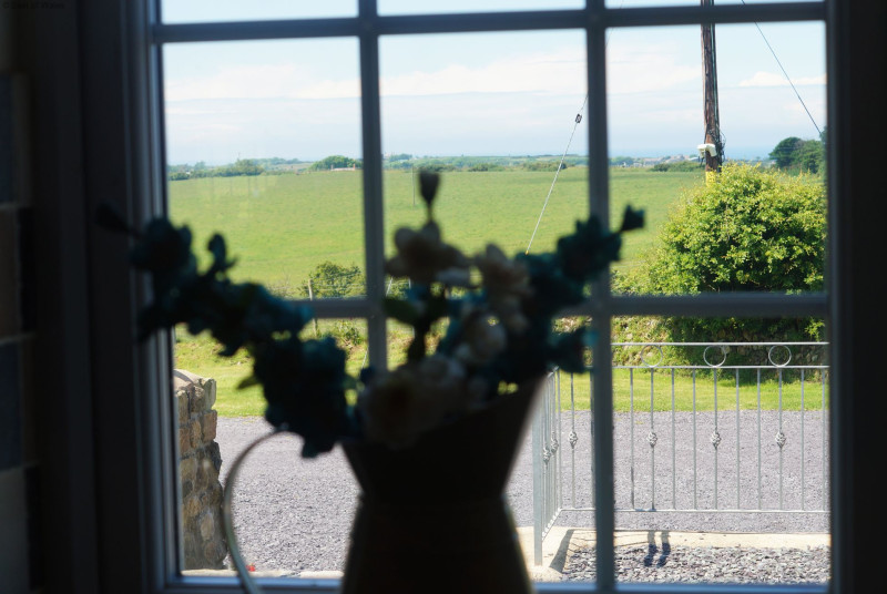 A spacious, cream 'shaker' style kitchen with a farmhouse pine table.