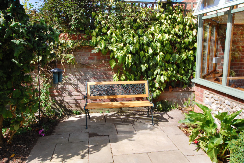 Another part of the garden with wooden bench.