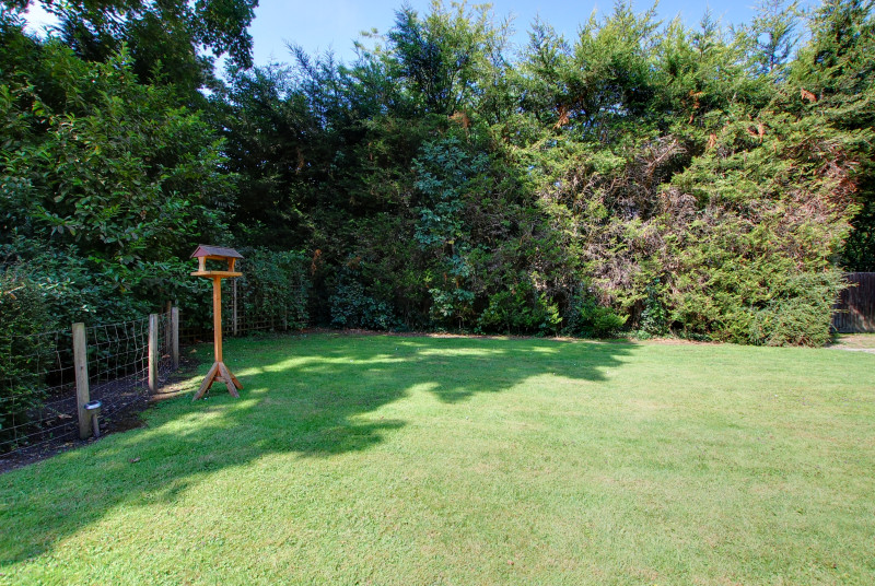 Fully enclosed rear garden with a lovely lawn and mature hedges