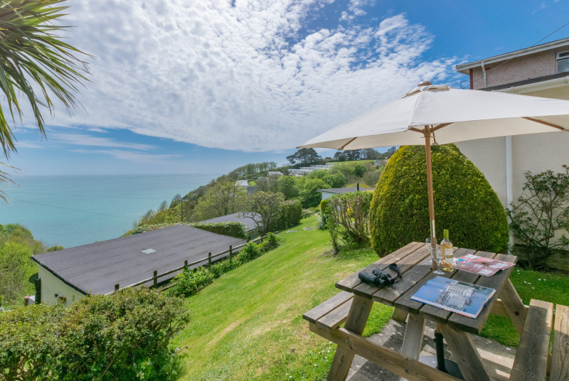 Outside: Paved patio area with picnic bench and sun parasol, perfect for 'al fresco' dining to make the most of the sea views.