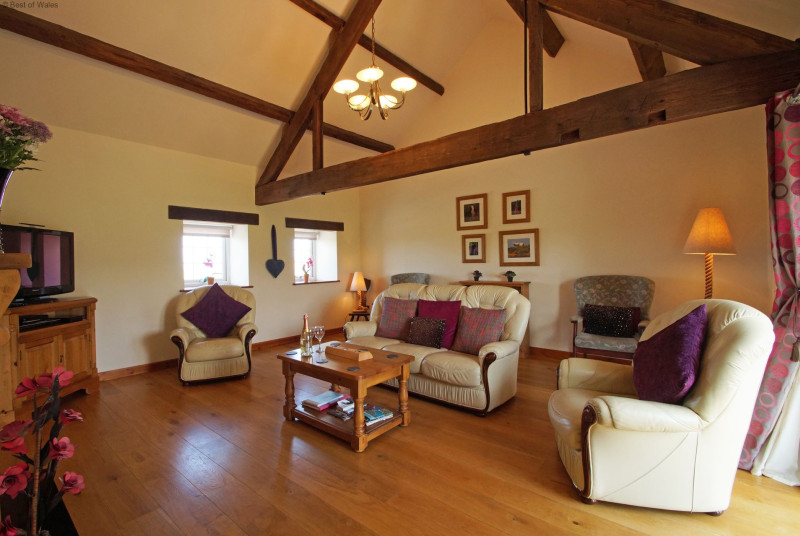 Living room with solid oak floor and comfortable, large leather sofas