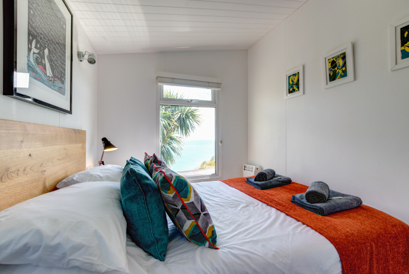 Bedroom: Double bed with views out sea. Stylish and coordinated bedroom, bedside tables and lamps. Separate dressing area with ample storage for clothes, full length mirror. Analogue Radio.