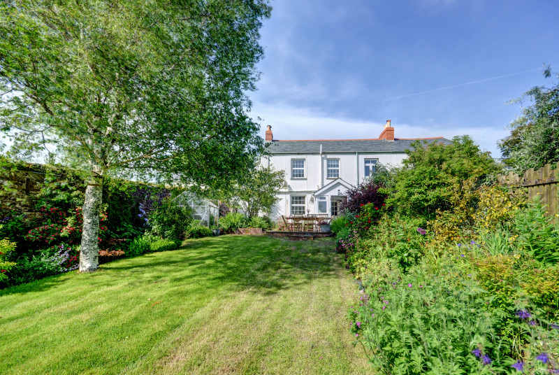 The mature rear garden is fully enclosed with a sheltered patio