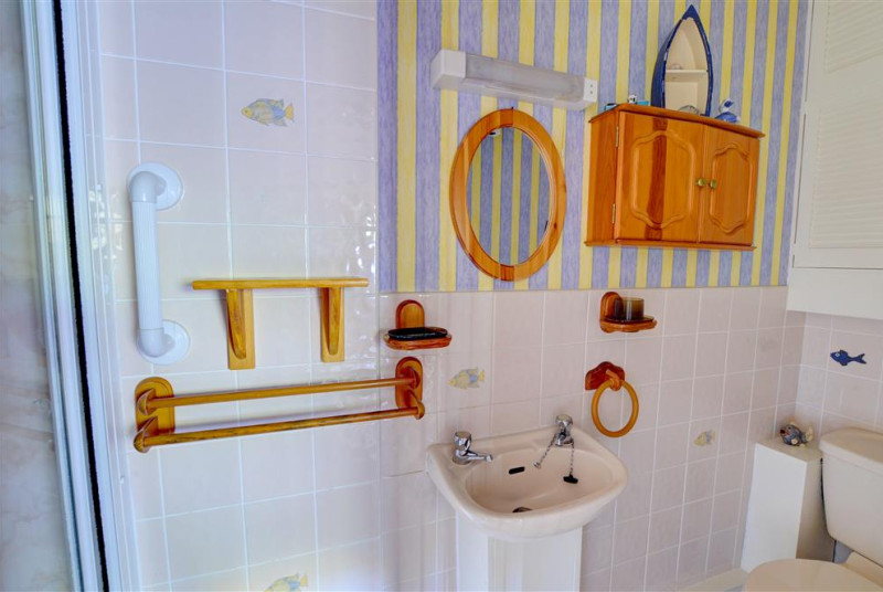 The en suite shower room has shower cubicle ( steps up), white WC and basin, and bright decor