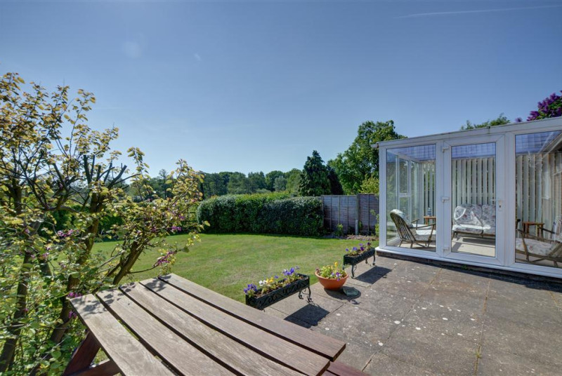 With plenty of outside space this patio can be enjoyed around this wooden picnic table.