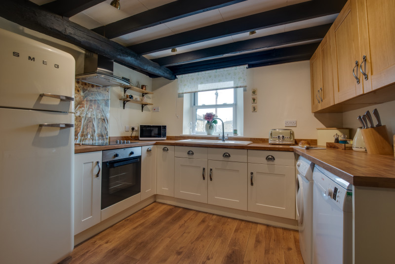 Well-equipped kitchen, beamed ceiling and views over the Hawes bridge and waterfall