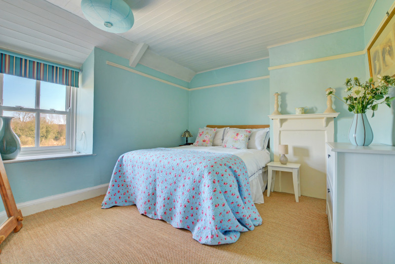 Charming double bedroom with a double bed and a large chest of drawers for storage