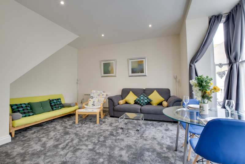 Living/dining room with large bay window and views of the sea