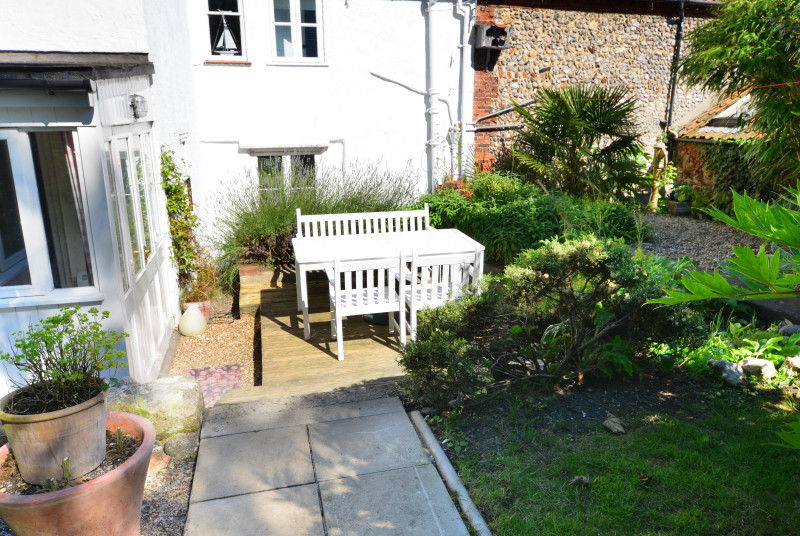 Fully enclosed lawned garden with a patio area, garden furniture and a barbecue, ideal for al fresco dining 