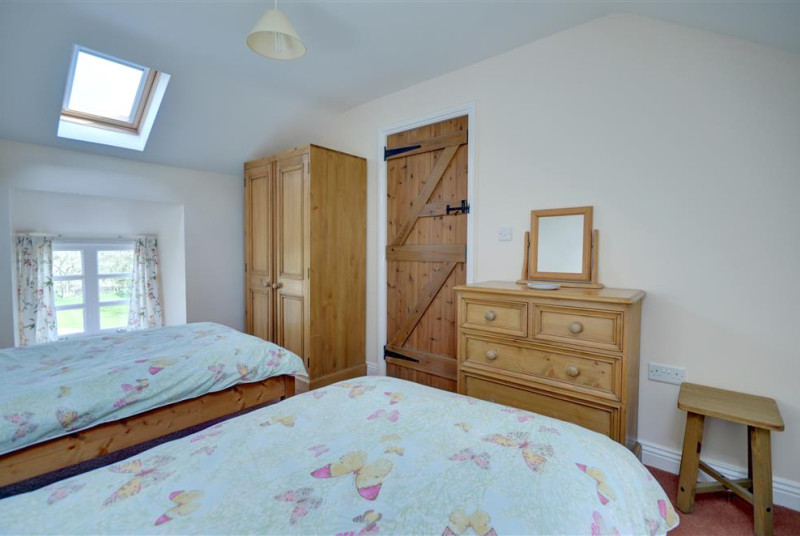 Twin beds with wardrobe and chest of draws.