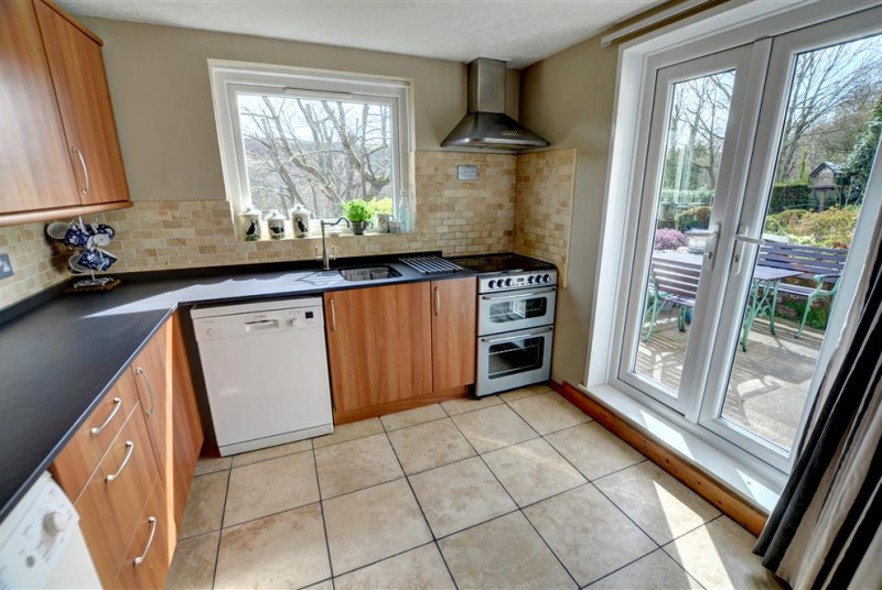 The fitted kitchen has a small freezer, dishwasher, washing machine and doors to garden